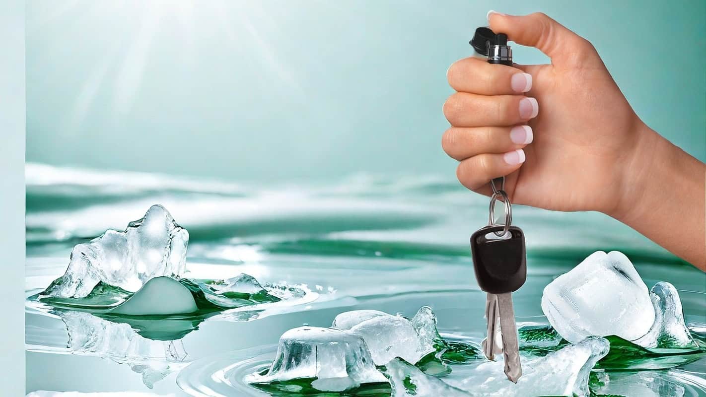 Hand holding car keys with ice cubes and green liquid background, symbolizing freshness and security.