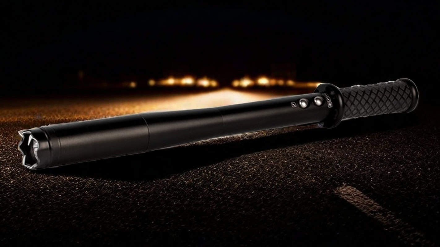 Black electric stun baton on a dark road background, showcasing rugged grip and controls.