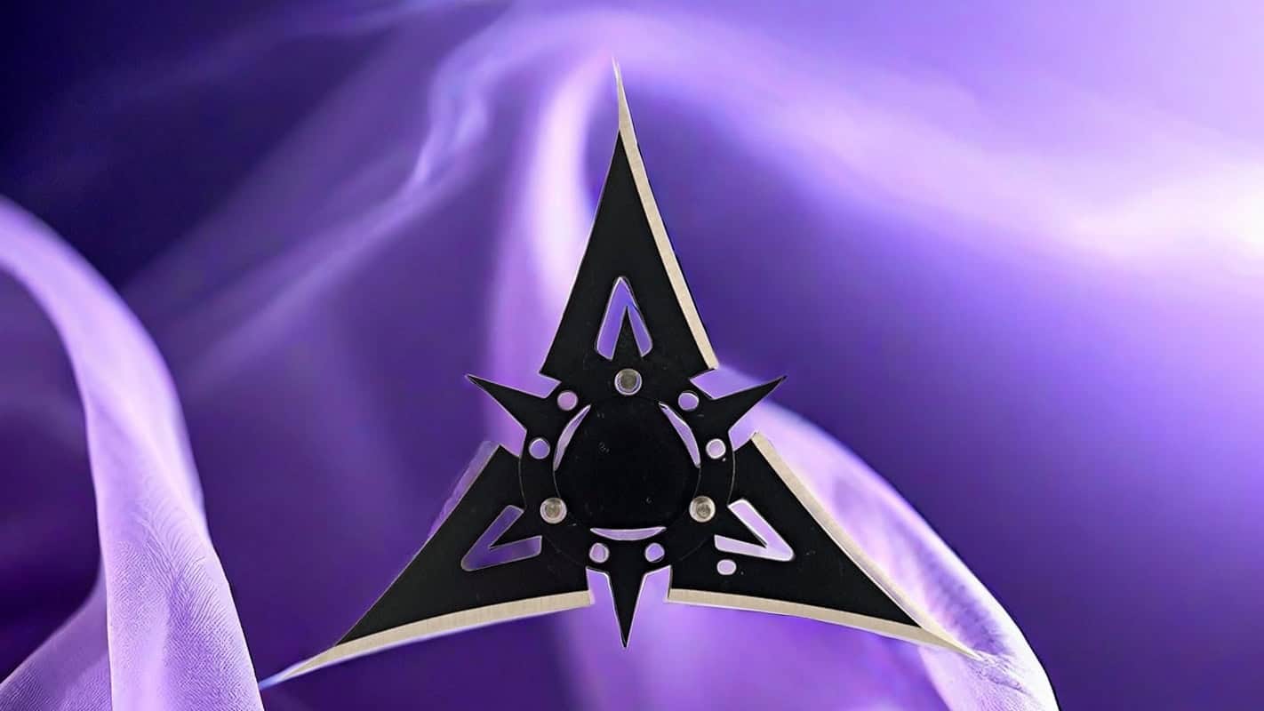 Black ninja star with silver edges against a purple background.